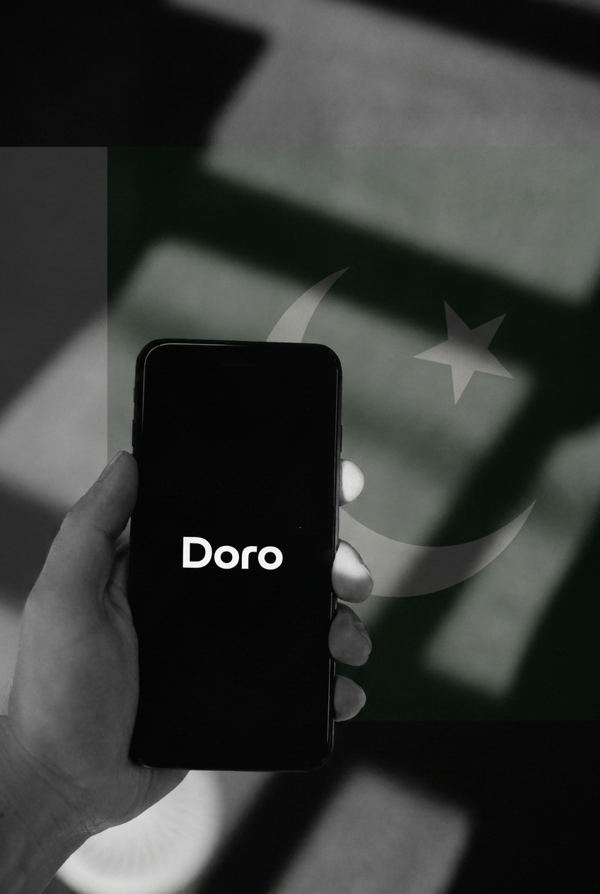 Doro delivery operator using the Nishan-powered pin-drop flow on a phone, with the Pakistan flag in the background